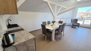 Una cocina y un comedor con mesa y sillas. en Apartament Camping Portowy, en Mrzeżyno