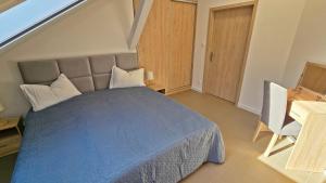 Un dormitorio con una cama con un edredón azul. en Apartament Camping Portowy, en Mrzeżyno