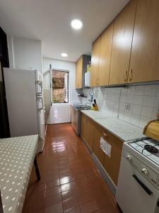 a kitchen with wooden cabinets and a white refrigerator at Adriatic Escape Apartment in Herceg-Novi
