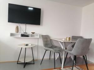 two chairs and a table with a television on a wall at Studio 28 in Bajina Bašta