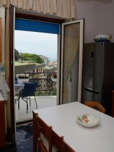 een keuken met een tafel en uitzicht op een balkon bij Belvedere 35 in Salerno