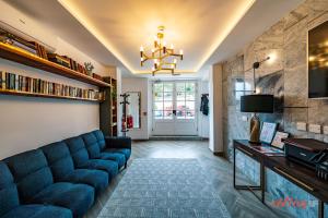 a living room with a blue couch and a chandelier at Yolanda Boutique Suites by Zzzing in Cospicua