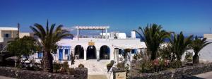 a large white building with palm trees and palm trees at Laokasti Villas in Oia