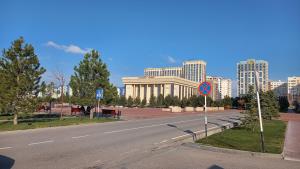eine leere Straße mit einem Gebäude und einem Straßenschild in der Unterkunft 2х комнатная квартира в ЖК Отау сити in Schymkent