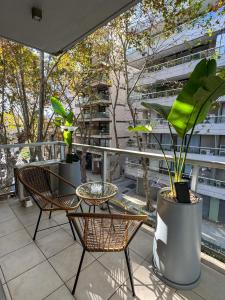 a balcony with two chairs and a table and plants at Foster Studio - Nicaragua in Buenos Aires