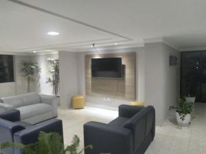 a living room with couches and a flat screen tv at Victory Flat Intermares in Cabedelo