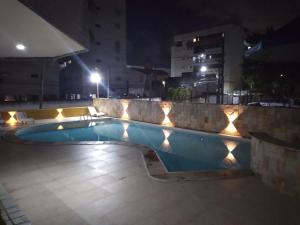 a swimming pool at night with lights around it at Victory Flat Intermares in Cabedelo