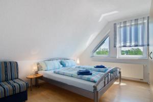 a bedroom with a bed and a chair at Ferienwohnungen Burgenmeister in Uhldingen-Mühlhofen