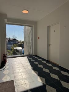 an empty room with a checkerboard floor and a door at Sadama Apartment in Haapsalu