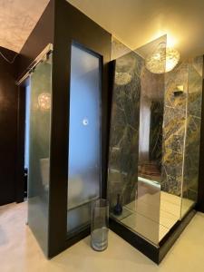 a glass shower in a bathroom with a mirror at Mini piscina idromassaggio giardino e vista a mare in Tencarola
