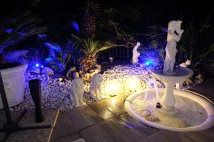 a fountain with cats in a garden at night at Mini piscina idromassaggio giardino e vista a mare in Tencarola +4 photos
