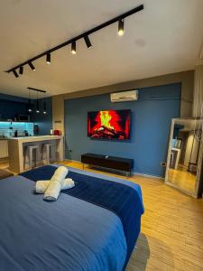 a bedroom with a large blue bed and a kitchen at Foster Studio - Nicaragua in Buenos Aires +46 photos