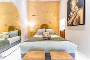 a bedroom with a large bed with two benches at Superbe appartement Bordelais plein de charme et lumineux avec terrasse in Bordeaux