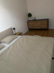 a bedroom with a large white bed and a dresser at Apartmán MDK in Námestovo +5 photos