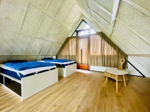 Zimmer mit 2 Betten und einem Tisch im Dachgeschoss in der Unterkunft De Vlier 8* in Nieuwvliet