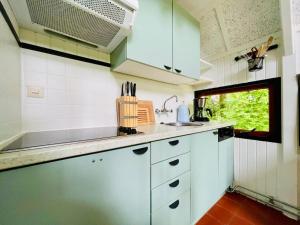 eine kleine Küche mit weißen Schränken und einem Fenster in der Unterkunft De Vlier 8* in Nieuwvliet + 20 Fotos