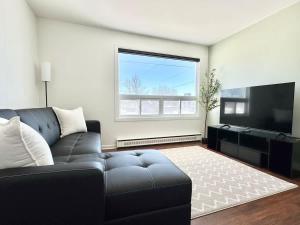 a living room with a couch and a flat screen tv at Le Cocooning - with EV Chrger Level 2 in Quebec City