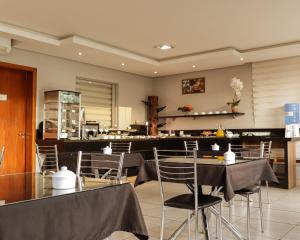 a restaurant with tables and chairs and a counter at Hotel Caminhos da Serra in Três Coroas