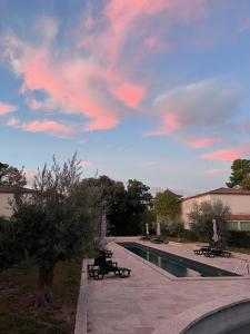 a swimming pool with benches and a cloudy sky at La Redorte Appartement au château 8 in La Redorte