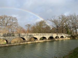 a rainbow over a stone bridge over a river at La Redorte Appartement au château 8 in La Redorte +1 photo