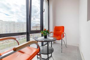 een kamer met een tafel, stoelen en een raam bij Комфортные апартаменты в центре города in Astana