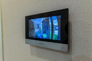 een televisie aan een muur met een foto van een stad bij Комфортные апартаменты в центре города in Astana