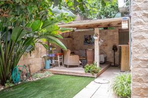 a garden with a patio with a table and chairs at דירת מסע בגליל in Bet Leẖem HaGelilit