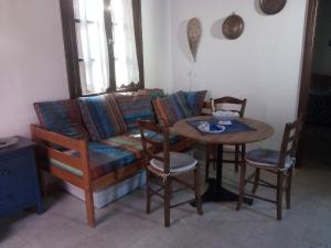 a living room with a couch and a table with chairs at Louloudi, charming townhouse in Skiathos