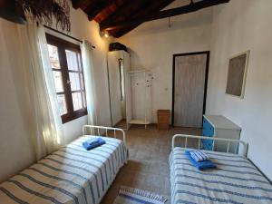 a bedroom with two beds and a window at Louloudi, charming townhouse in Skiathos