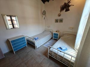 a bedroom with two beds and a blue dresser at Louloudi, charming townhouse in Skiathos Town +10 photos