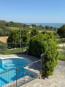 a fence around a swimming pool with the ocean in the background at Il Castellano Vacanze in Porto SantʼElpidio
