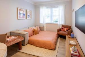 a small living room with a couch and a chair at The Holkham Uno - One Bed Apartment Fairy Bower in Sydney