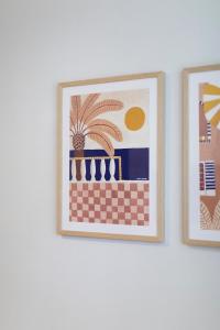 two framed pictures of a palm tree on a wall at The Holkham Uno - One Bed Apartment Fairy Bower in Sydney