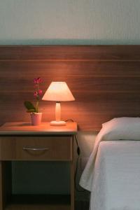 eine Lampe auf einem Nachttisch neben einem Bett in der Unterkunft Hotel Pousada Bonita - 150m Metrô Paraiso e 1Km do inicio Av Paulista in São Paulo