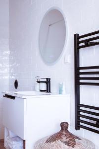 a white bathroom with a sink and a mirror at Mar-Ria 8 in Fuzeta