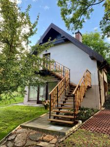 a house with a staircase in front of it at Apartament W Dolinie Modrzewi in Kamienna Góra