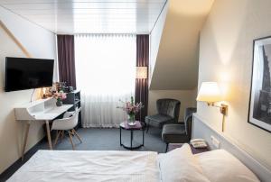 a hotel room with a bed and a desk at Hotel Alte Post in Krefeld