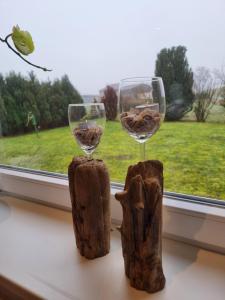 two wine glasses sitting on a window sill at Ferienhaus AKate - Sauna, Kamin, Garten, 3 Hunde in Kronprinzenkoog +9 photos