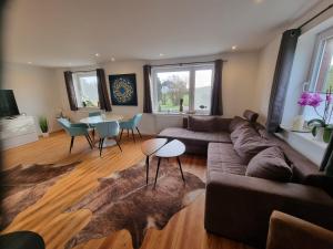 a living room with a couch and a table at Ferienhaus AKate - Sauna, Kamin, Garten, 3 Hunde in Kronprinzenkoog