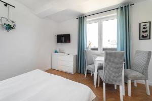 a bedroom with a bed and chairs and a table at Pokoje Gościnne Dominika in Jastarnia
