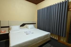 a bedroom with a white bed with white towels on it at Pondok Alas Guests House in Gretek