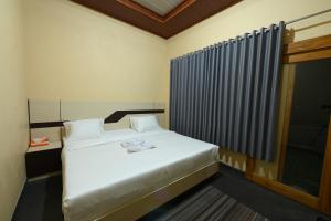 a bedroom with a white bed and a window at Pondok Alas Guests House in Gretek