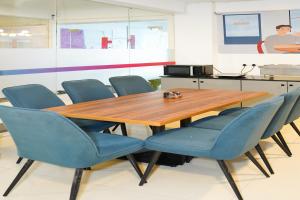 a wooden table and blue chairs in a room at Housr 78 Madhapur Hitech City Near Yashoda Hospital in Hyderabad