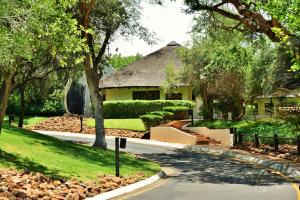 a house with a thatched roof and a road at Kwa Maritane Lodge in Ledig
