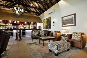 a lobby with a bar with couches and a table at Kwa Maritane Lodge in Ledig