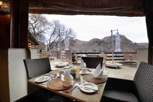 a table with plates and utensils on a balcony at Kwa Maritane Lodge in Ledig