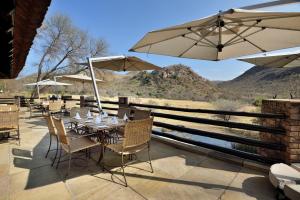 a table and chairs with umbrellas on a patio at Kwa Maritane Lodge in Ledig