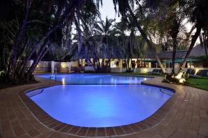 a large swimming pool with blue water at night at Kwa Maritane Lodge in Ledig