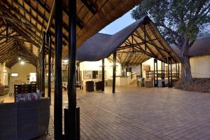 a pavilion with a tree in the middle of a building at Kwa Maritane Lodge in Ledig