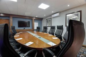 a conference room with a large wooden table and chairs at Kwa Maritane Lodge in Ledig